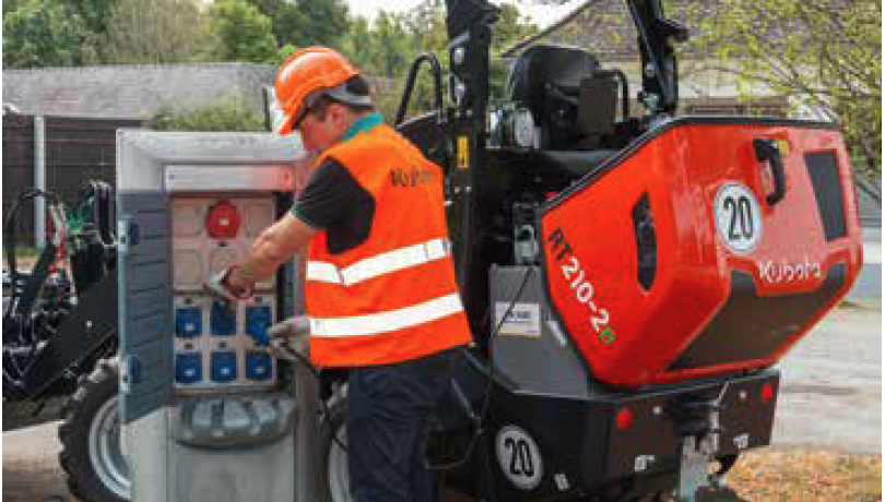 A construction worker charging his Kubota electric wheel loader.